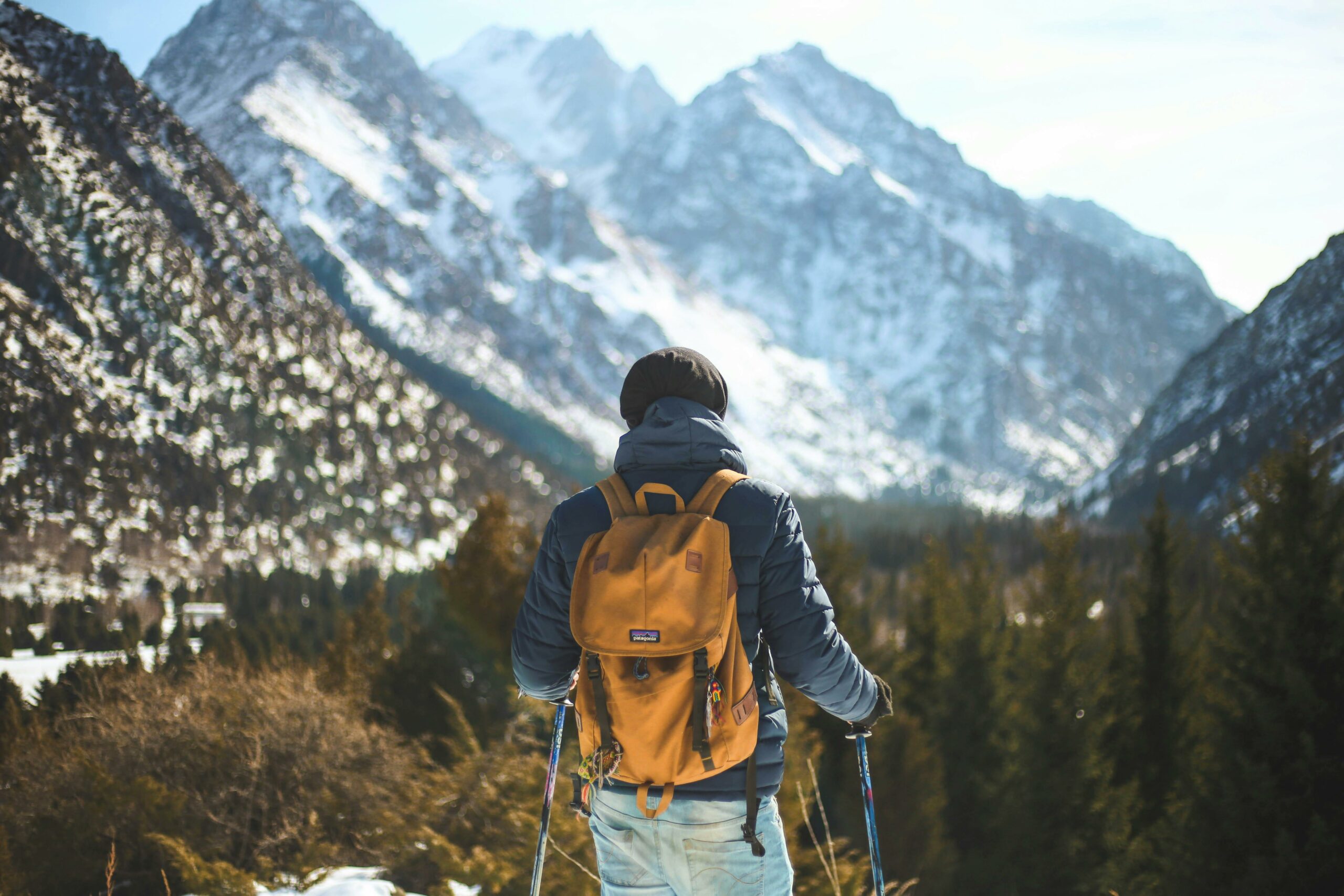Randonneur en balade hivernale dans le Queyras avec sac &agrave; dos et montagnes enneig&eacute;es